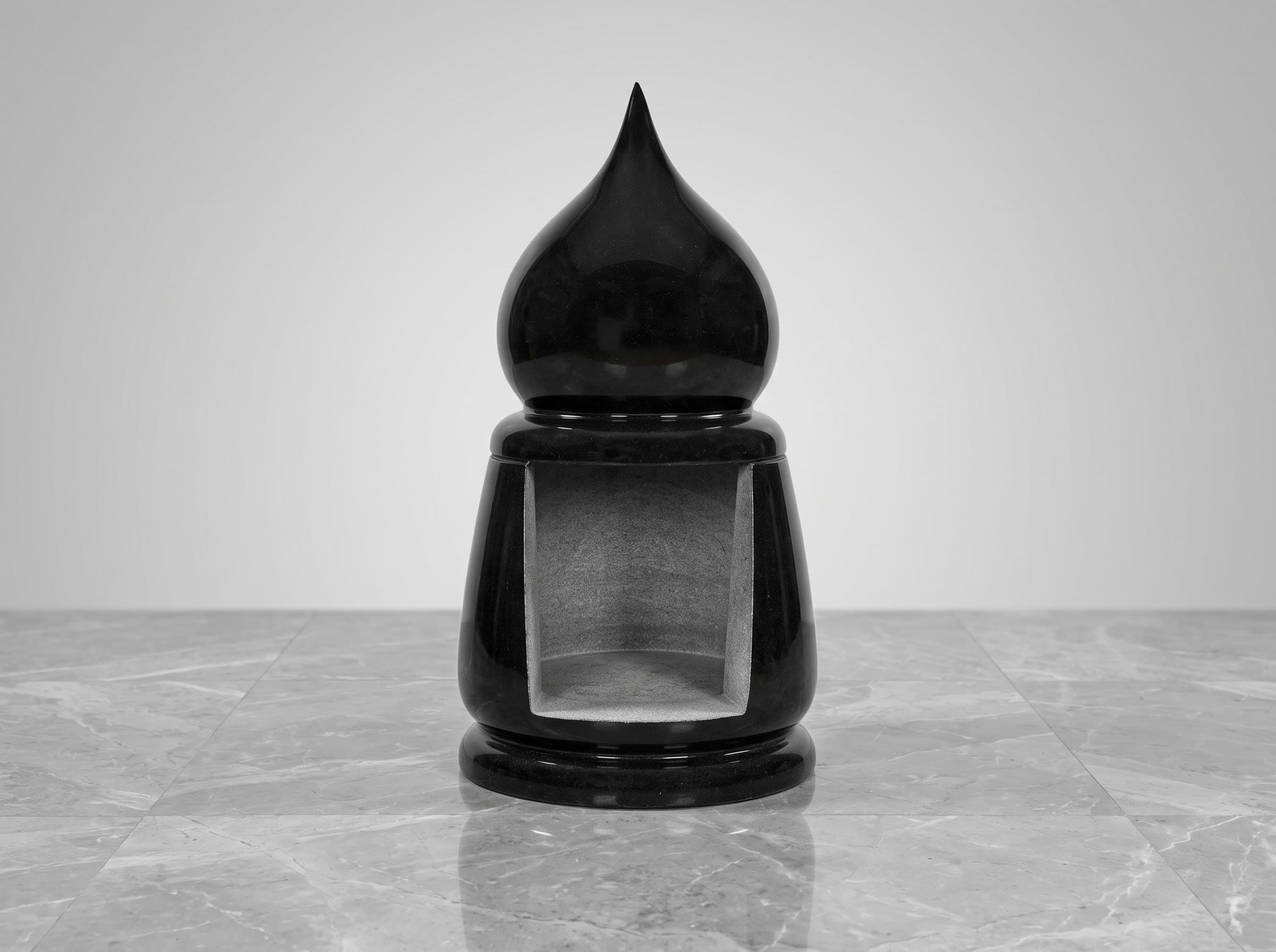 Black granite deepa lamp with a domed finial on a marble surface