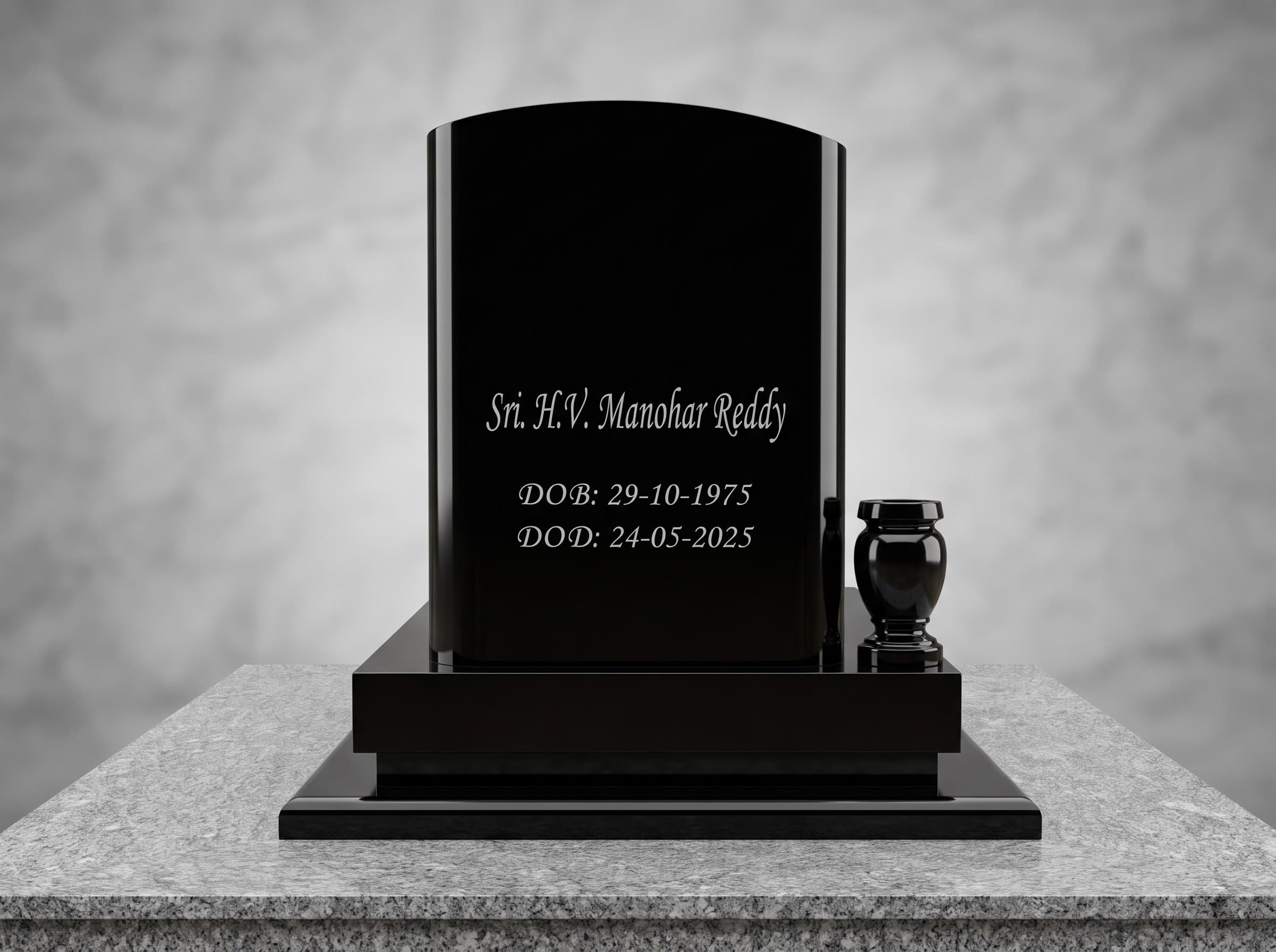 Engraved black granite headstone with a granite vase on a grey granite plinth