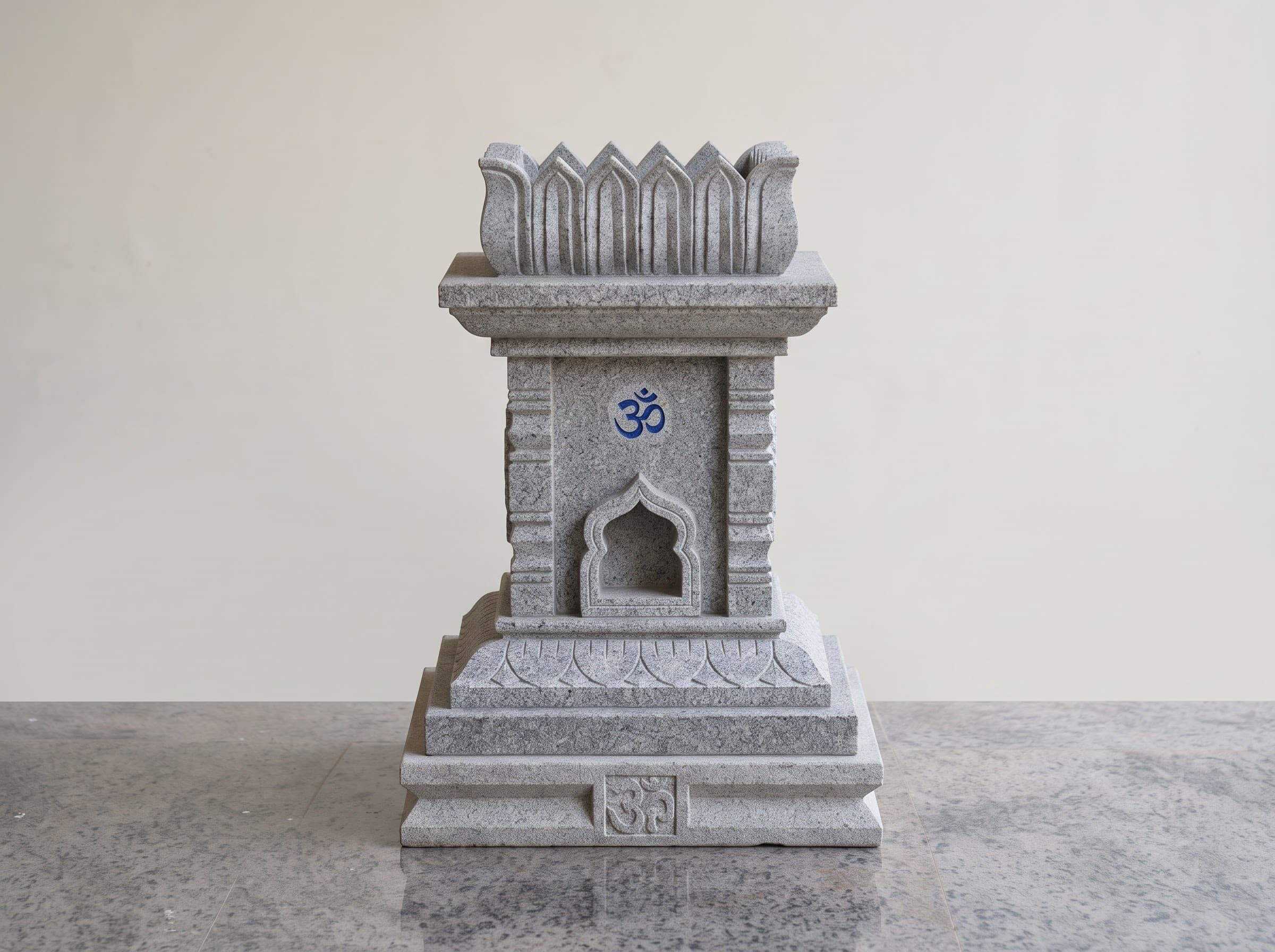 Grey granite tulsi katte with an Om carving and arched lamp niche