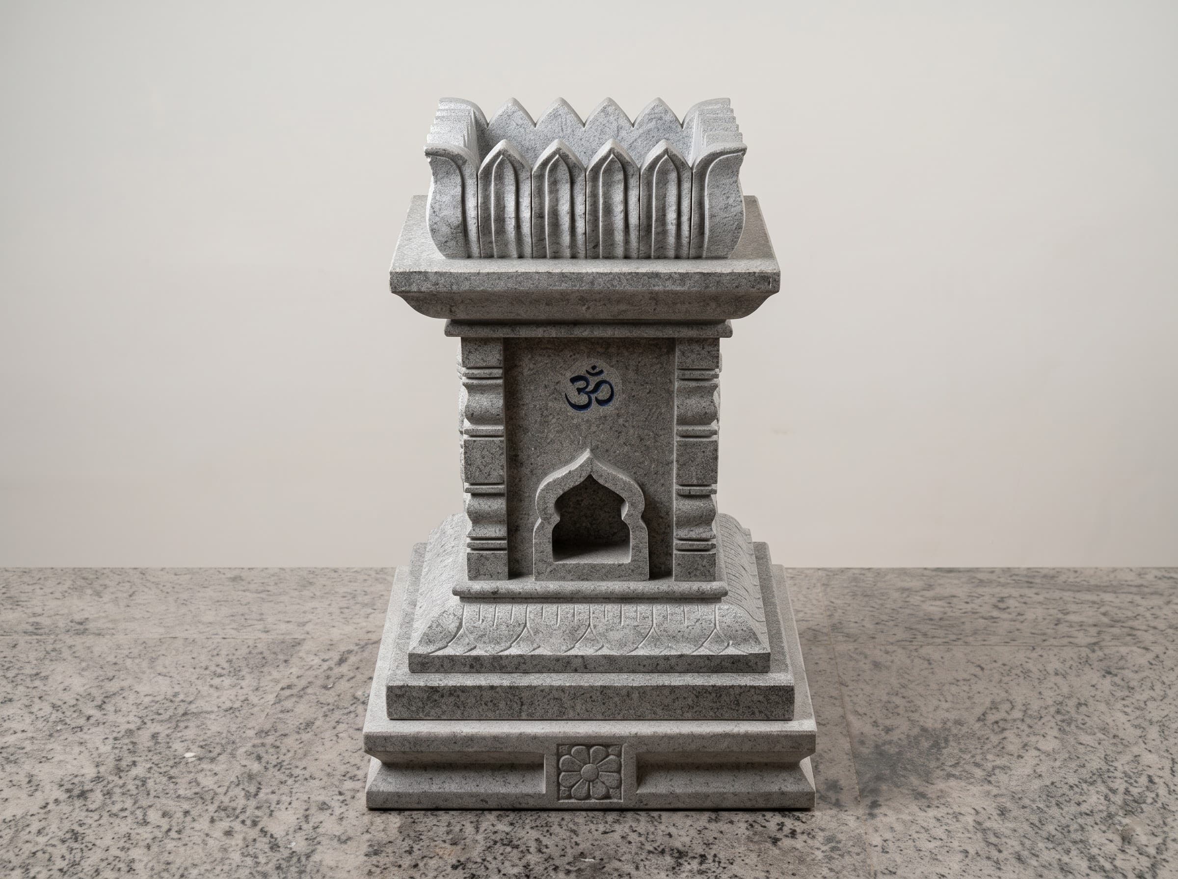 Detailed view of a carved grey granite tulsi katte with petal crown